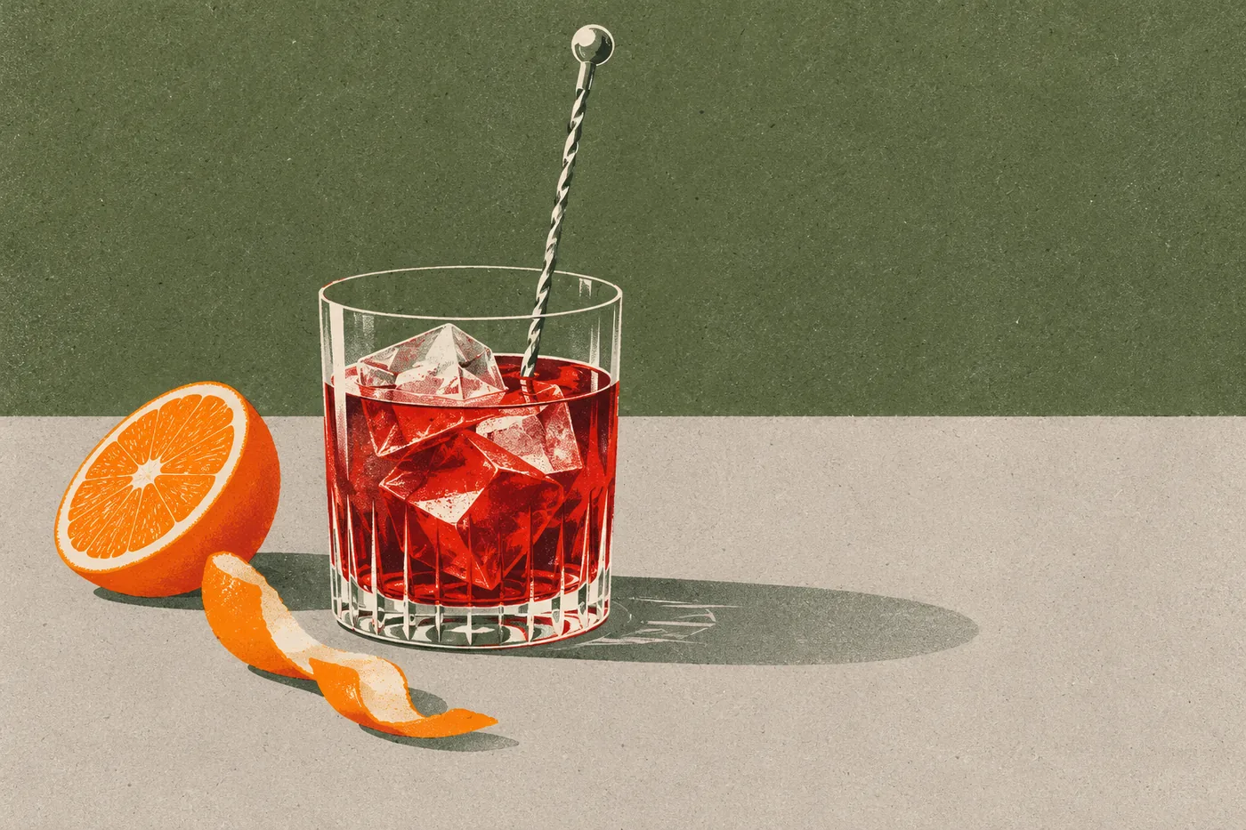 Negroni wird im Tumbler mit dem Barlöffel gerührt, daneben eine halbierte Orange und ein Streifen Orangenschale